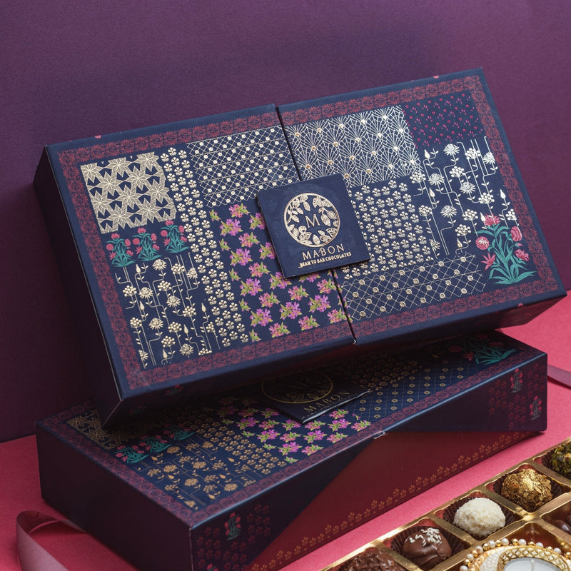 Mabon Chocolate Dabba, open — chocolate dragees, truffles, and a festive diya